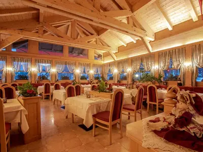 a restaurant with tables and chairs in a room at Hotel Barance in Alleghe