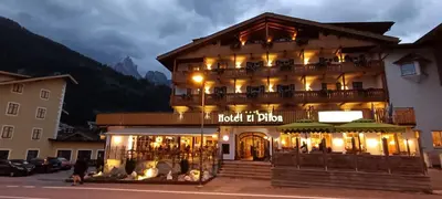 a hotel in the mountains with a sign on it at Hotel El Pilon in Pozza di Fassa
