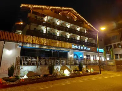 a hotel building at night with a sign on it at Hotel El Pilon in Pozza di Fassa