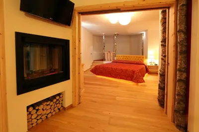 a bedroom with a bed and a fire place at Hotel El Pilon in Pozza di Fassa