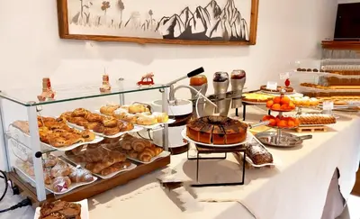 a buffet line with various pastries and other desserts at Hotel Kronplatzer Hof in Rasun di Sopra