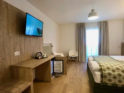 a hotel room with a bed and a television on the wall at Hotel Kronplatzer Hof in Rasun di Sopra