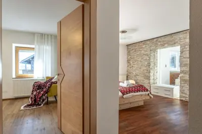 a bedroom with a bed and a brick wall at Hotel Kronplatzer Hof in Rasun di Sopra