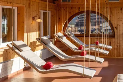 a row of hammocks in a room with wooden walls at Hotel Kronplatzer Hof in Rasun di Sopra