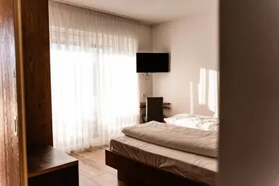 a bedroom with a bed and a large window at Residence Tannhof in Caldaro