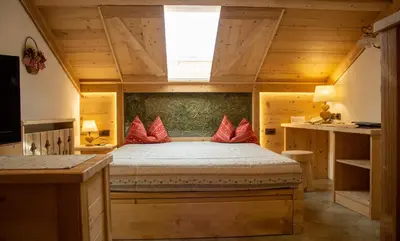 a bedroom with a bed with red pillows at Residence Lastè in Moena