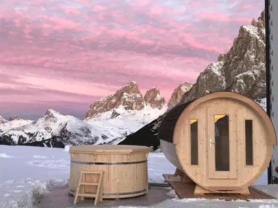 a sauna and a trash can in front of a mountain at Hotel Col di Lana in Canazei
