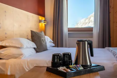 a hotel room with a bed with a coffee maker on a table at Hotel Col di Lana in Canazei