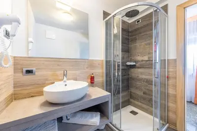 a bathroom with a sink and a shower at Hotel Col di Lana in Canazei