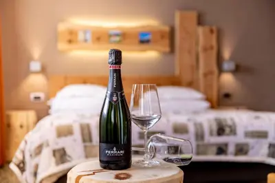 a bottle of wine on a table with a glass at Hotel Col di Lana in Canazei