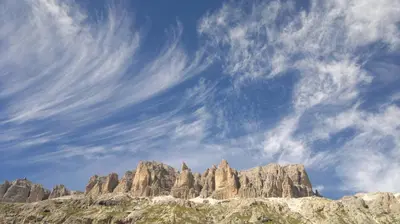 a group of rocky mountains under a cloudy sky at Hotel Col di Lana in Canazei