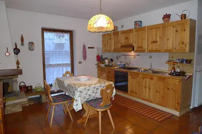 a kitchen with a table and a table and chairs at Condominio La Mont 2 in Piaia