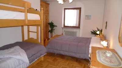 a bedroom with two beds and a bunk bed at Condominio La Mont 2 in Piaia