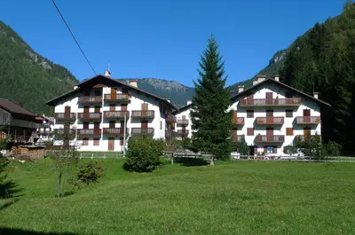 a large apartment building in a field with a tree at Condominio La Mont 2 in Piaia