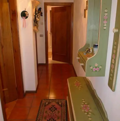 a hallway with a table and a door and a rug at Condominio La Mont 2 in Piaia