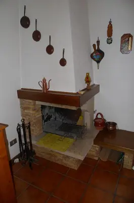 a kitchen with a brick fireplace with pots and pans at Condominio La Mont 2 in Piaia