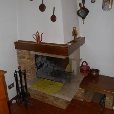 a living room with a brick fireplace with a mantle at Condominio La Mont 2 in Piaia