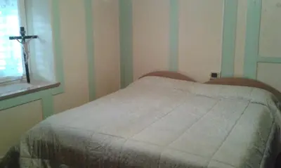 a bedroom with a bed with a cross on the wall at Casa Sicina in Sicina