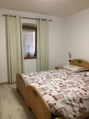 a bedroom with a bed with a comforter and a window at Casa Sicina in Sicina