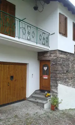 a house with a wooden door and a balcony at Casa Sicina in Sicina