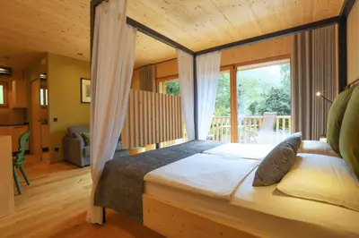 a bedroom with a canopy bed with a large window at Birkenhof in Marlengo