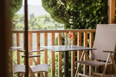a table and two chairs and a vase of flowers on a porch at Birkenhof in Marlengo