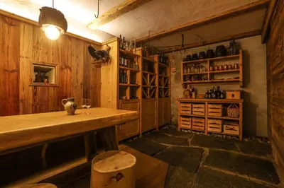 a room with a table and a shelf with wine glasses at Birkenhof in Marlengo