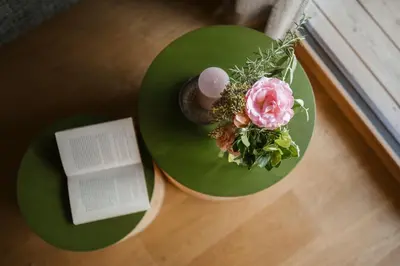 two green plates with a pink flower and a book at Birkenhof in Marlengo