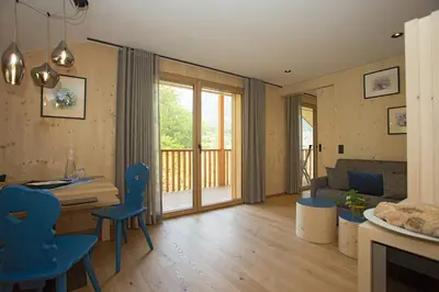 a living room with a table and chairs and a couch at Birkenhof in Marlengo