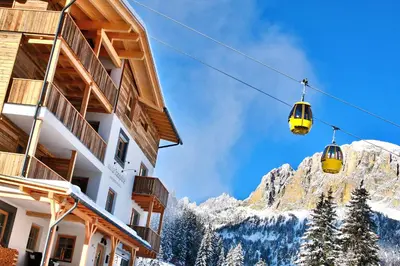 a pair of ski lifts in front of a mountain at B&B La Tranquillitè in Corvara in Badia
