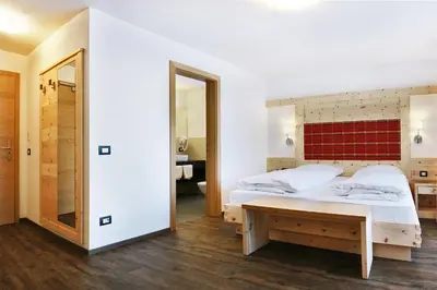a bedroom with a bed and a mirror at B&B La Tranquillitè in Corvara in Badia