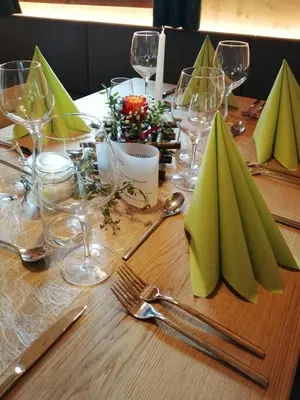 a table with green napkins and wine glasses on it at Oberhauser Hütte Rodenecker - Lüsner Alm in Luson