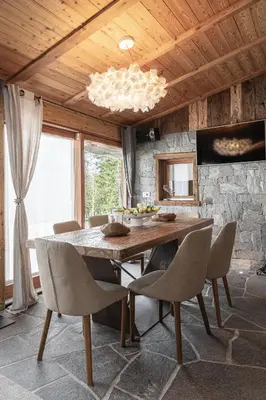 a dining room with a large wooden table and chairs at Cain Comfort Chalet in Fondo