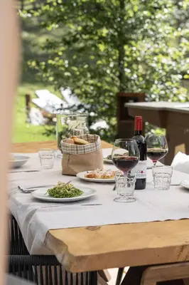 a table with glasses of wine and food on it at Cain Comfort Chalet in Fondo
