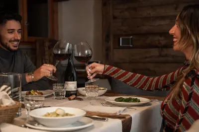 a group of people sitting at a table with wine glasses at Cain Comfort Chalet in Fondo