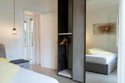 a bedroom with a bed and a window at Fior Apartments Schiller in Merano