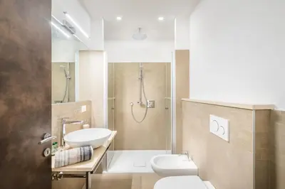 a bathroom with a toilet and a sink and a shower at Fior Apartments Schiller in Merano