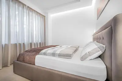 a small bed with two pillows on it in a room at Fior Apartments Schiller in Merano