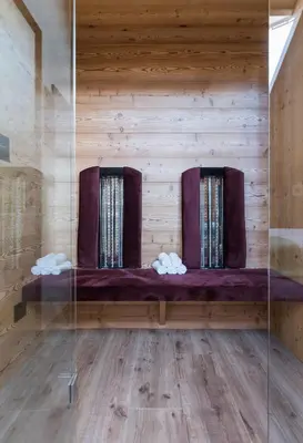 a bench in a room with wooden walls at Les Pizades in San Cassiano