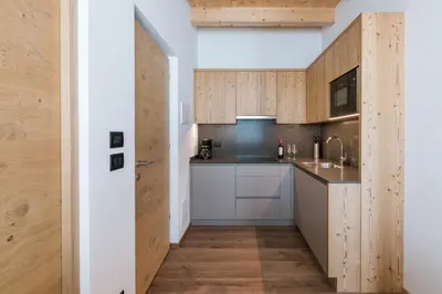 a kitchen with wooden cabinets and a sink at Les Pizades in San Cassiano