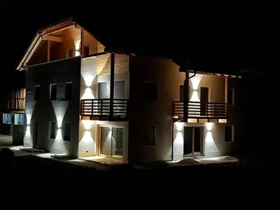 a building with lights on the side of it at night at Les Pizades in San Cassiano