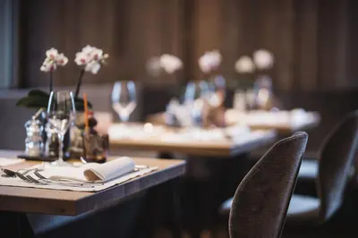 a table with plates and utensils and flowers on it at Autentis in Rasùn di Sotto