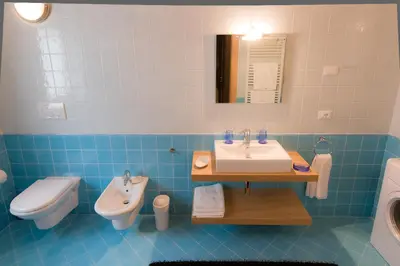 a blue and white bathroom with a sink and a toilet at Villa Edelweiss in Alleghe