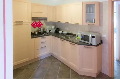 a kitchen with white cabinets and a microwave at Villa Edelweiss in Alleghe