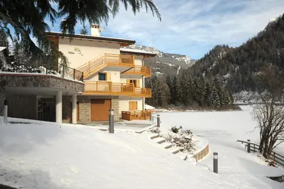a house in the snow with a snow covered yard at Villa Edelweiss in Alleghe
