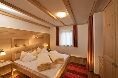 a bedroom with a bed with white pillows at Ciasa Sunara in Colfosco