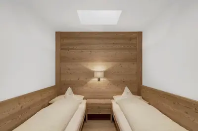 a row of beds in a room with a light at Ciasa Sunara in Colfosco