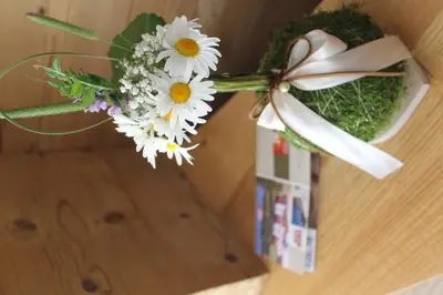 a bouquet of flowers in a box on a table at Ciasa Sunara in Colfosco