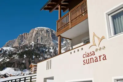 a hotel with a mountain in the background at Ciasa Sunara in Colfosco
