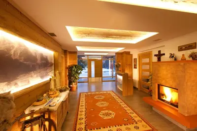a living room with a fireplace and a mantle at Ciasa Sunara in Colfosco